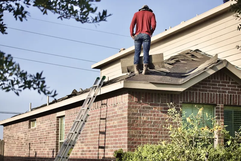 Professional roofer working on a residential roof in Sand Hills